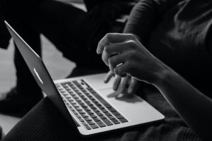 A person typing on a macbook.