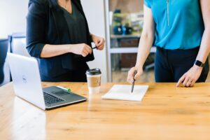 2 ladies explaining professional SEO services at a wooden table.