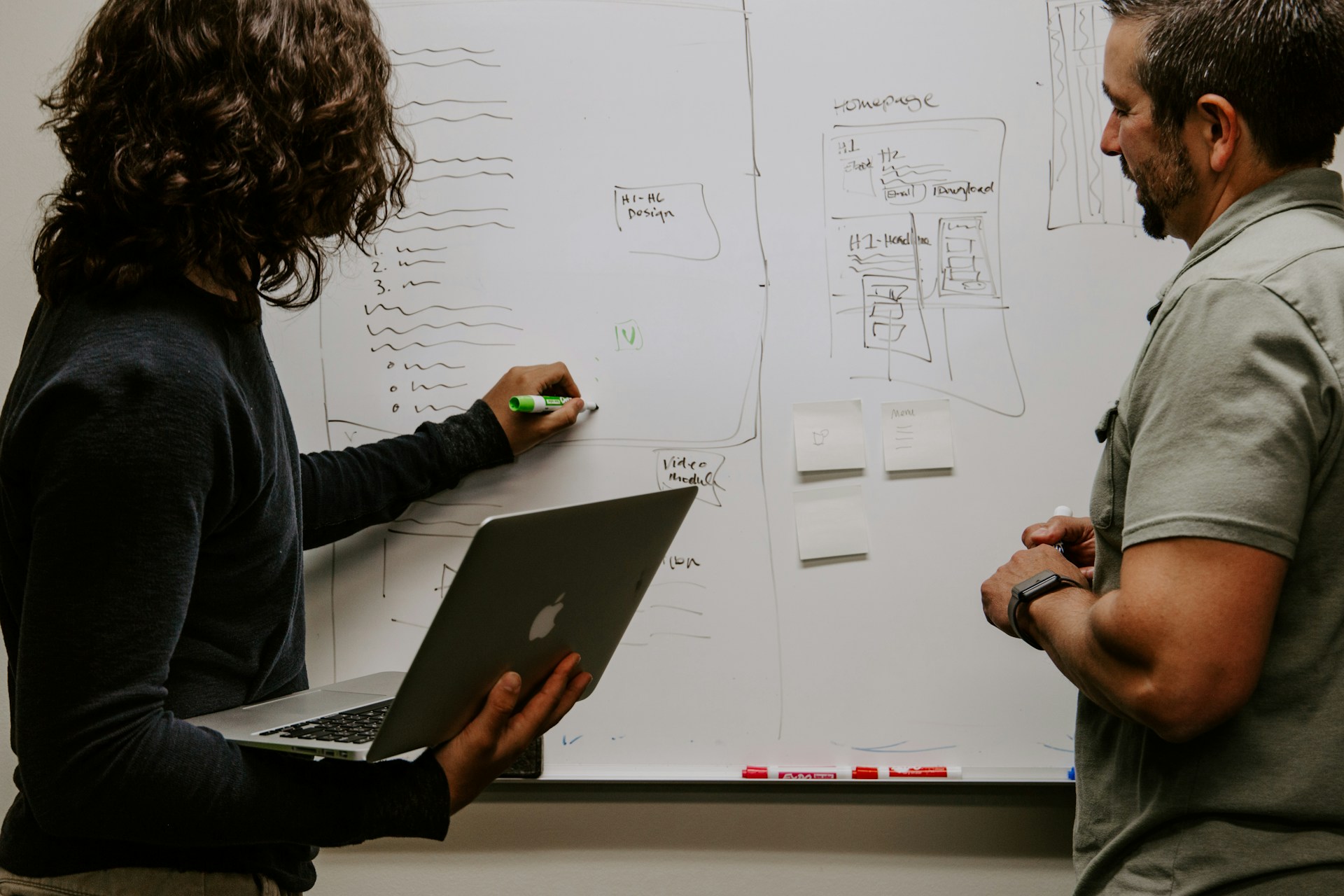 An SEO services provider explaining the service to a client on a white board.