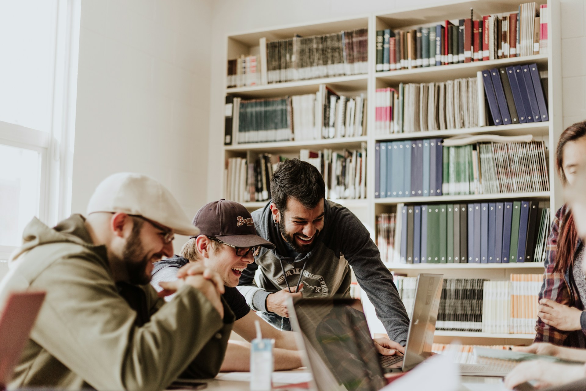 4 People working together around a table in a library to represent a digital marketing agency in South Africa.