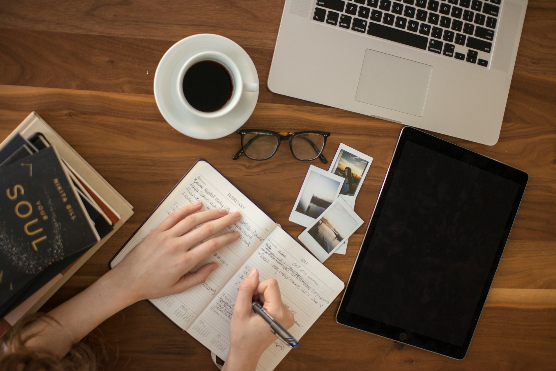 A bunch of stuff on a desk with a notebook to represent a content plan.